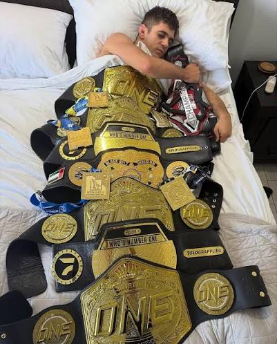 Mikey Musumeci dormindo com seus cinturões do ONE Championship